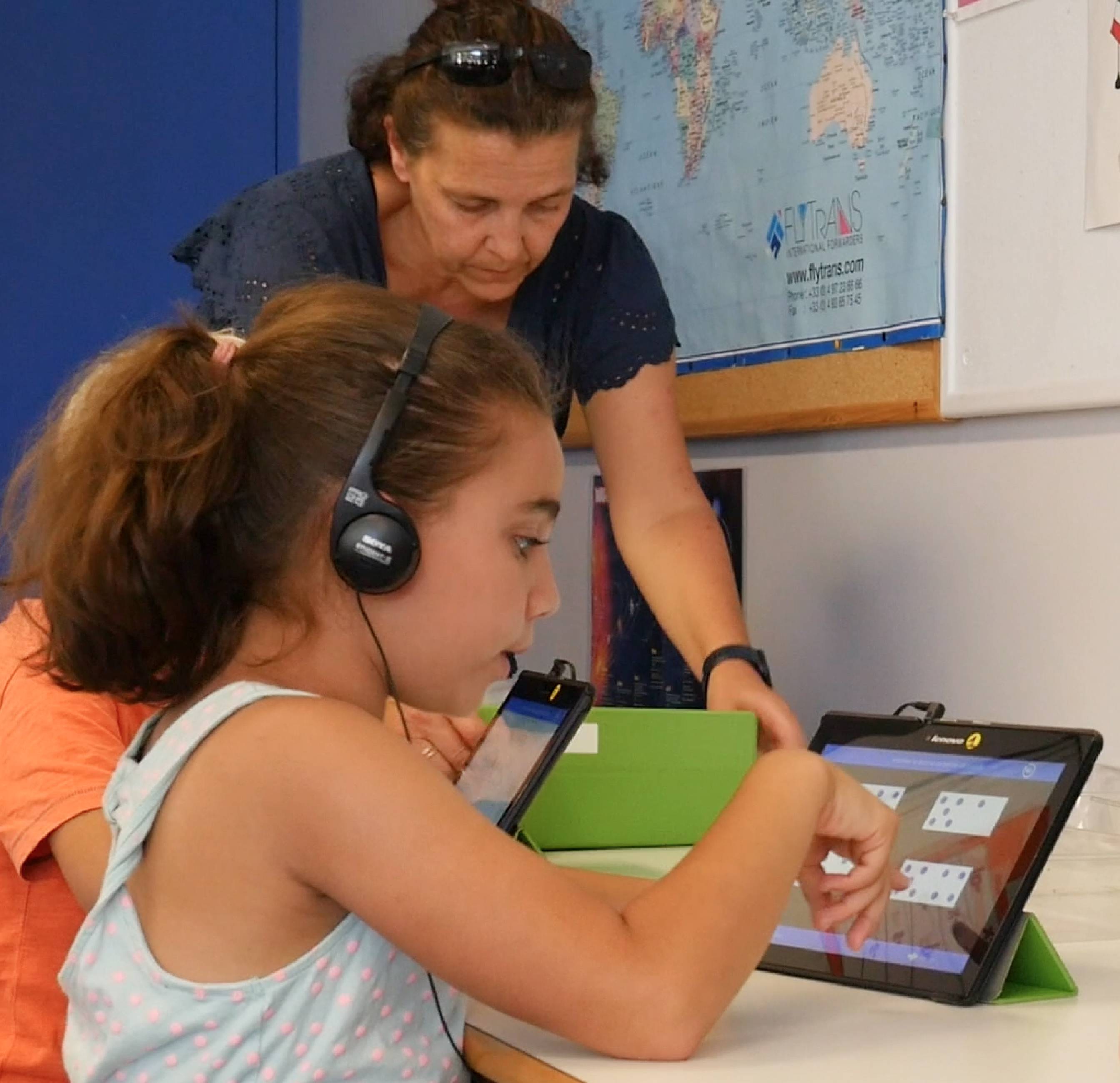 Élève et enseignante devant une tablette